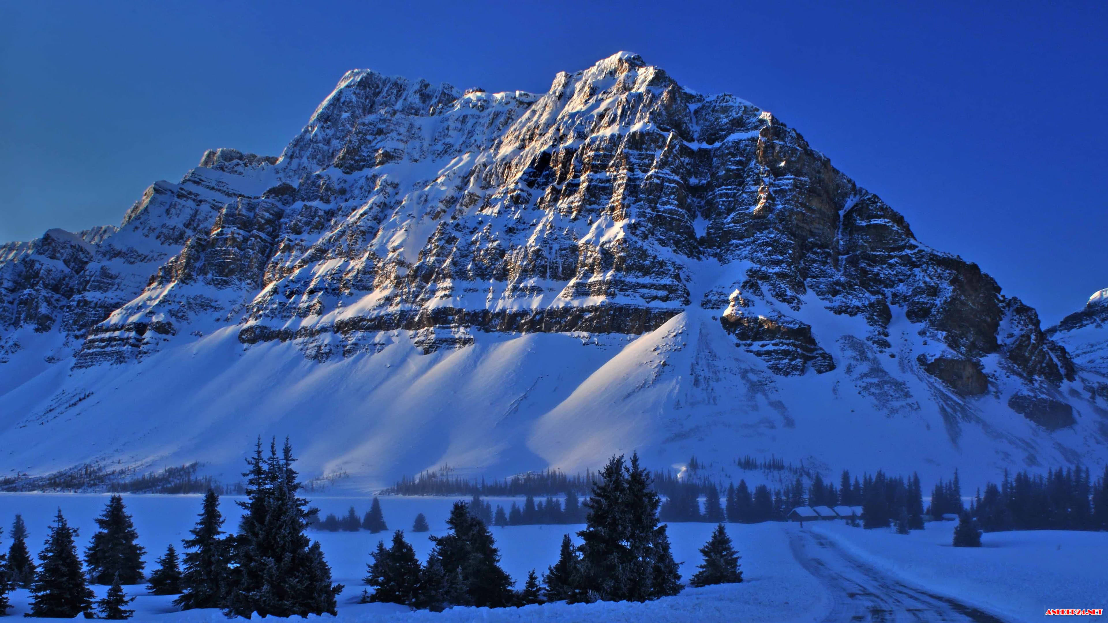 Stunning 4K winter landscape with snow-capped mountains and a frozen lake