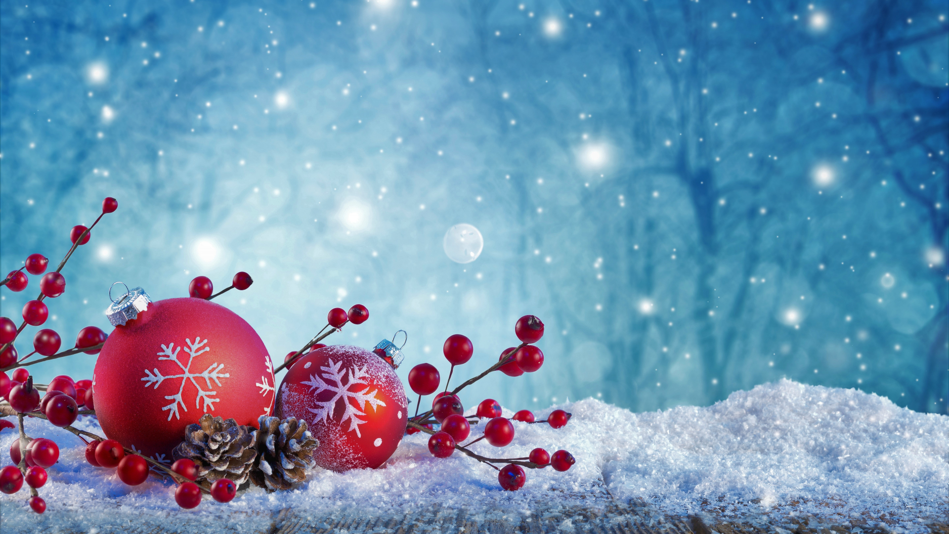 Red Christmas ornaments with snowflakes and holly berries on a snow-covered surface, with a blurred snowy forest background