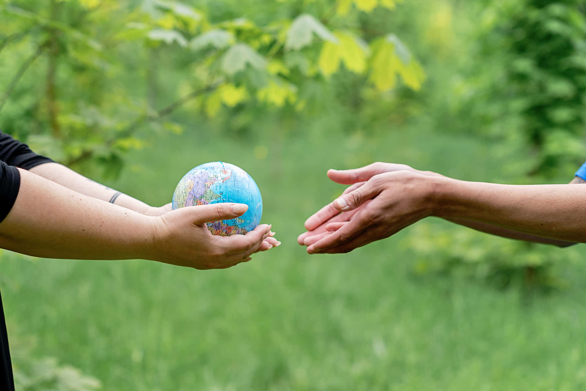 Hands Passing The Globe Wallpaper
