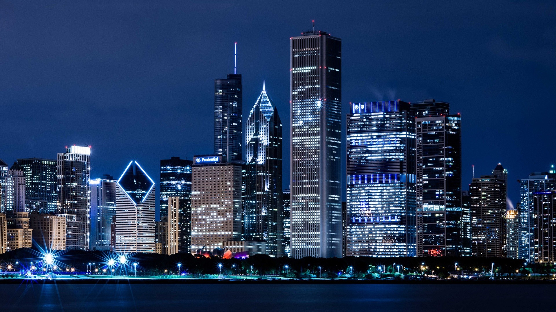 Stunning night view of the Chicago skyline illuminated with city lights, reflecting on the calm waters of Lake Michigan