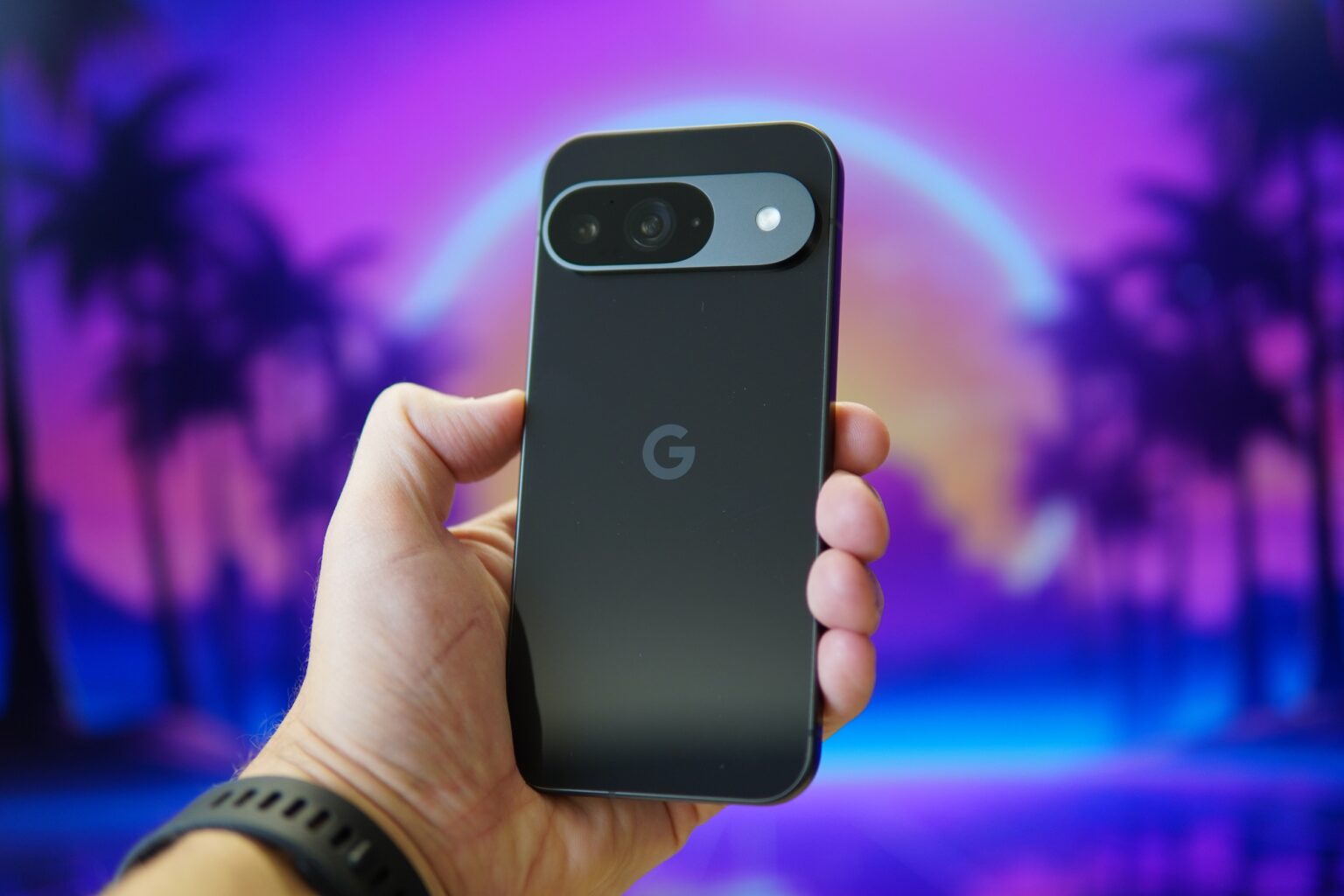 A hand holding a Google Pixel 7 phone against a vibrant, vaporwave-inspired background