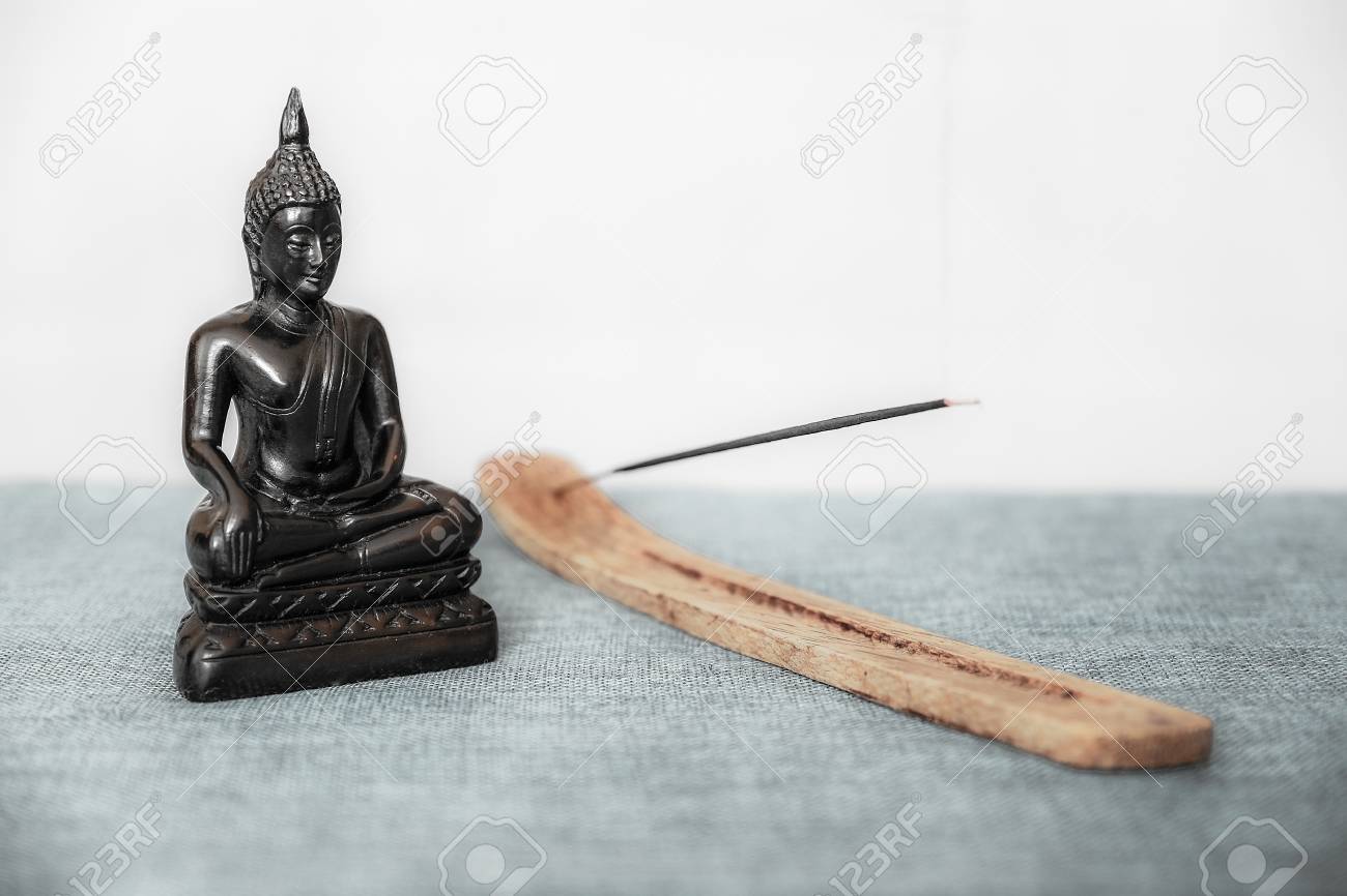A Decorative Statue Of Buddha On The Background Incense