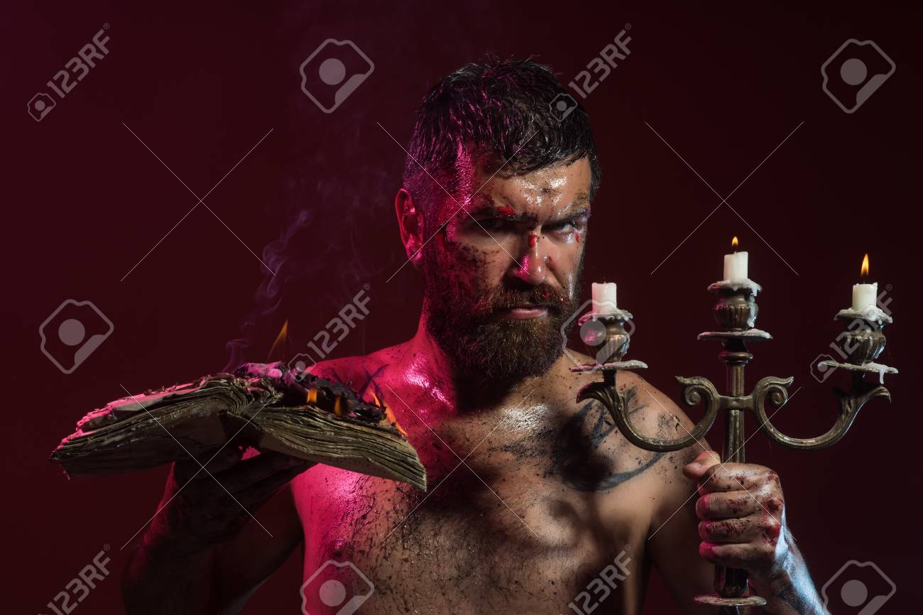 Man Hipster Hold Book And Candles Burning On Purple Background