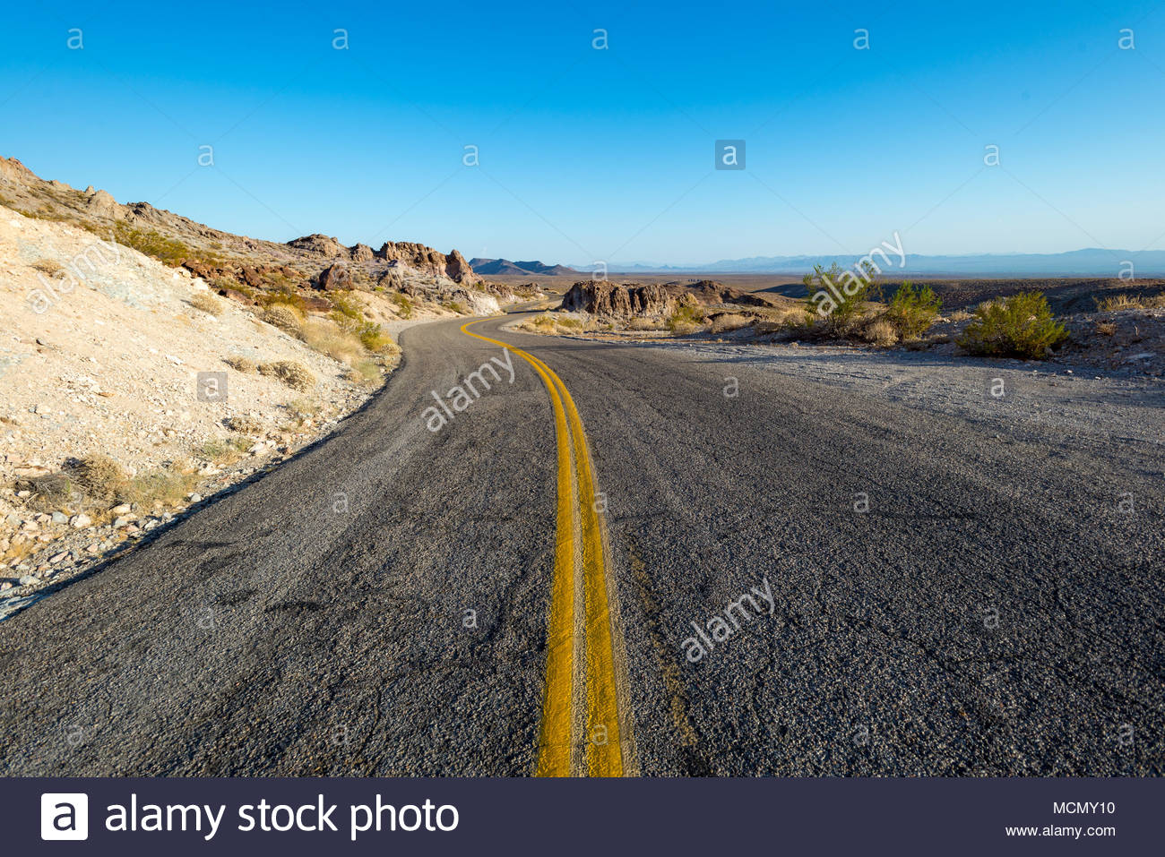 Long Winding Road Through The Mojave Desert Blue Sky And