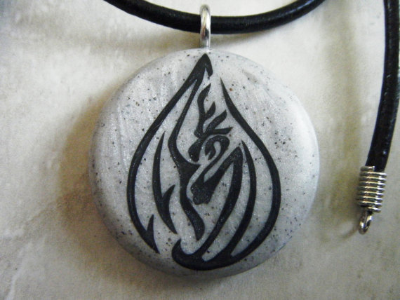 Dragon Tear Drop Hand Carved On A Grey Granite Color Background