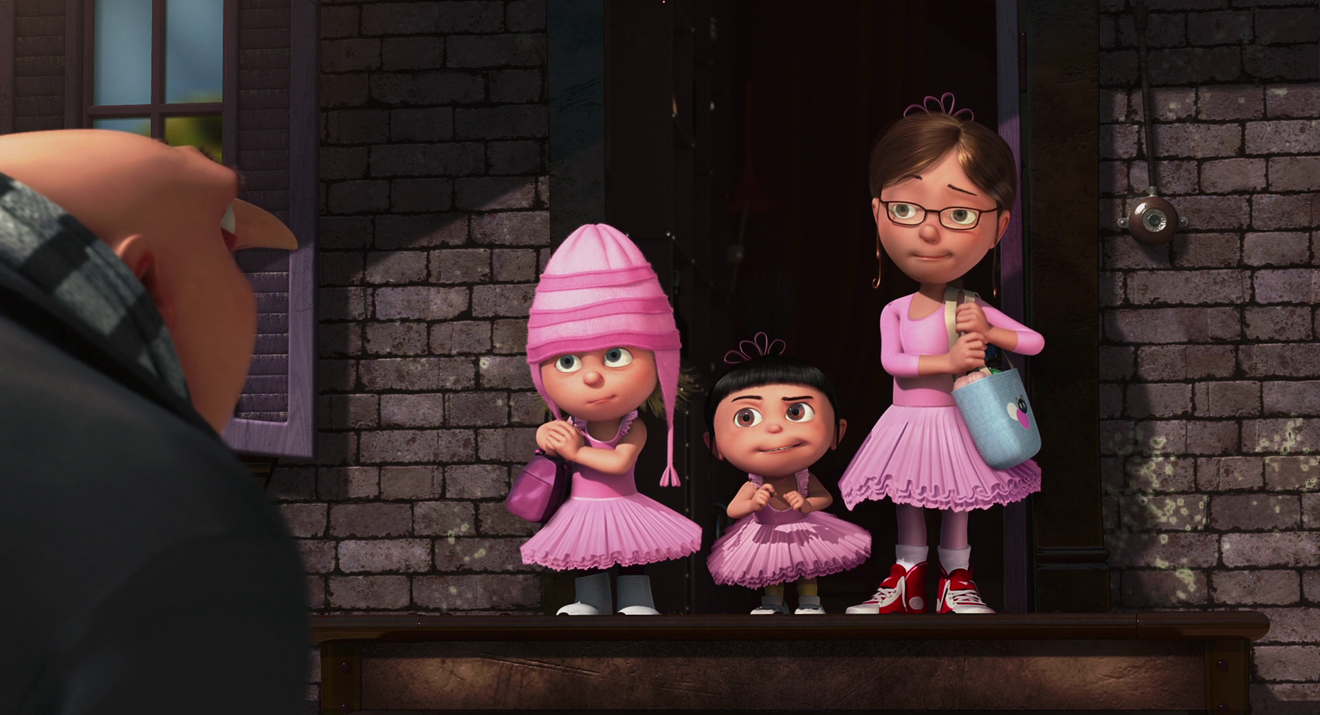 Three girls in pink tutus standing on a porch from Despicable Me