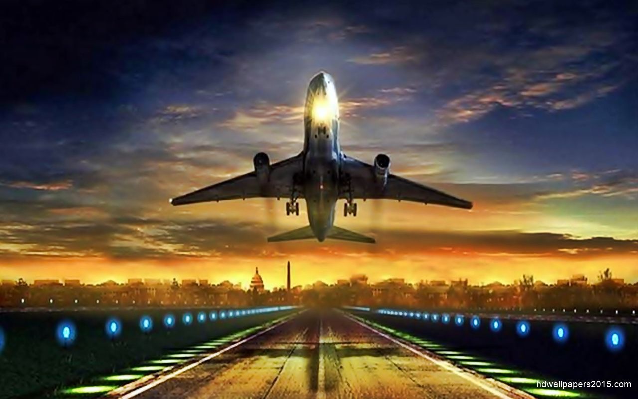 A passenger airplane taking off into the sunset over a city skyline