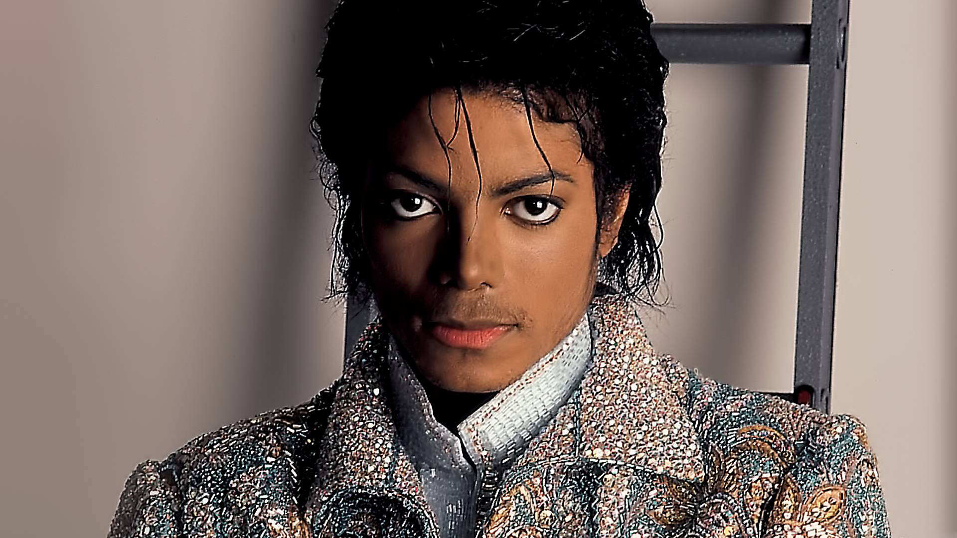 Close-up portrait of Michael Jackson, highlighting his intense gaze and embellished jacket