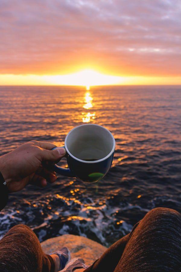 Person Holding Blue Cup Looking At Sunset Sunrise Beach