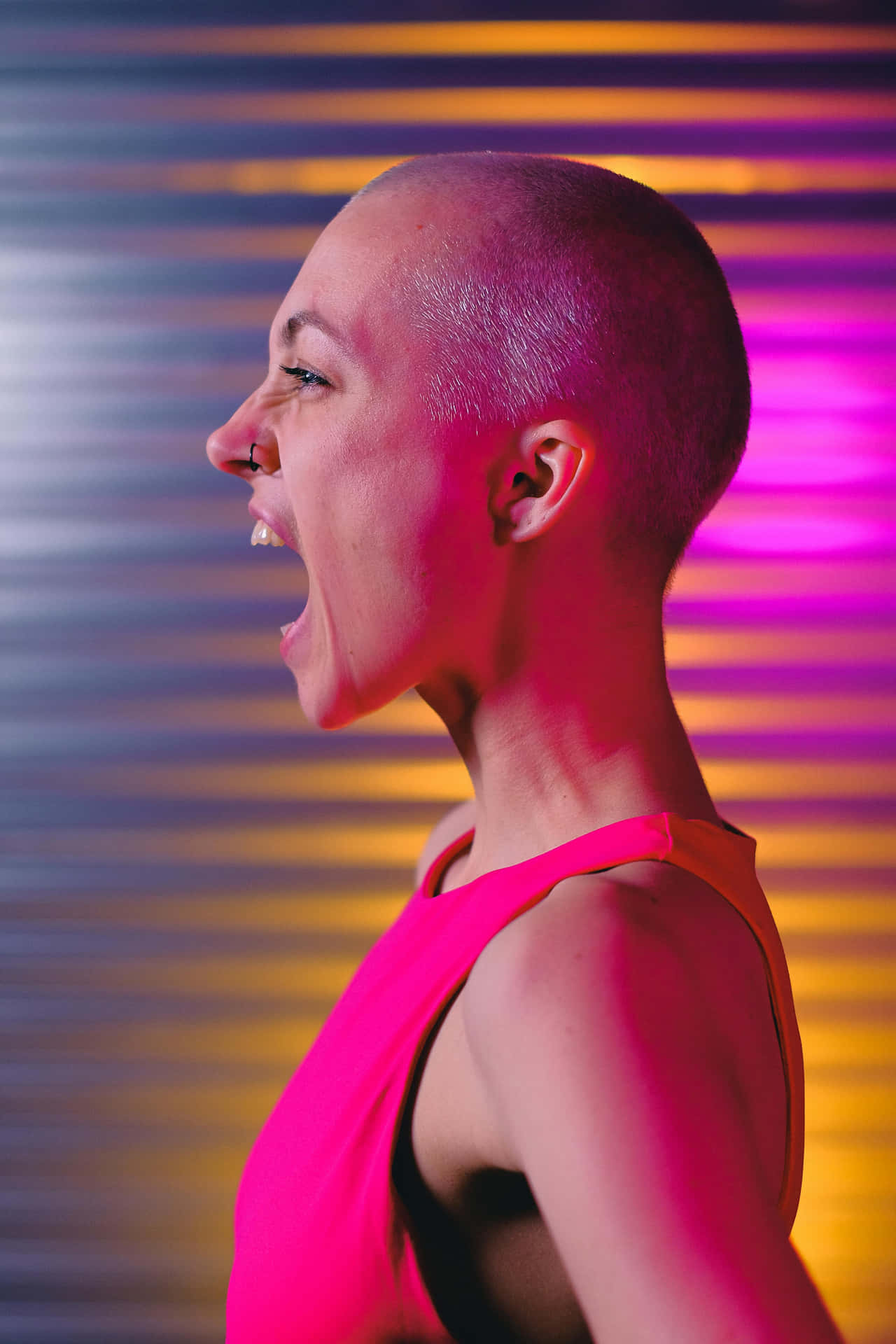 Bald Woman Laughing Against Colorful Wallpaper