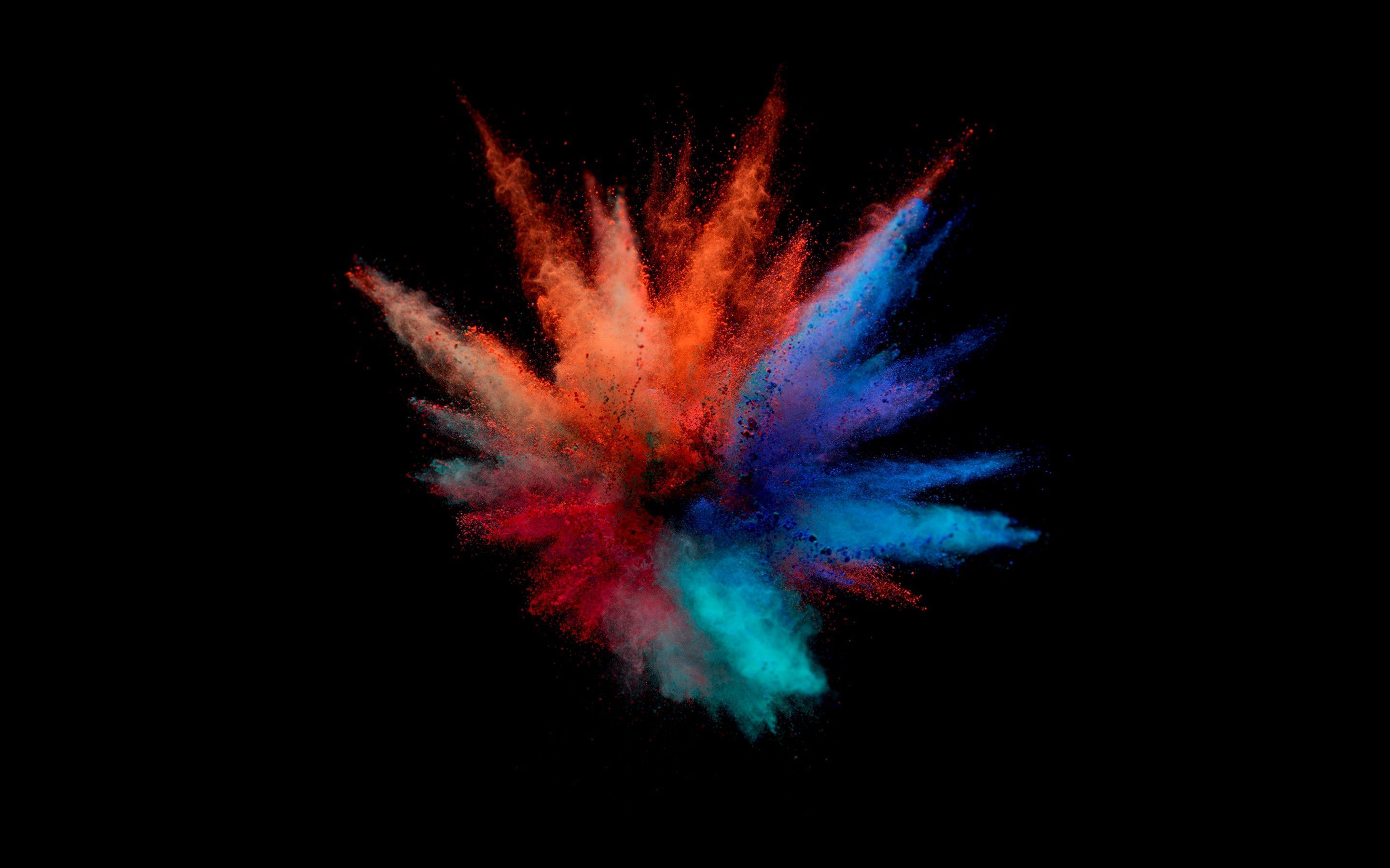 A vibrant explosion of colorful powder on a black background