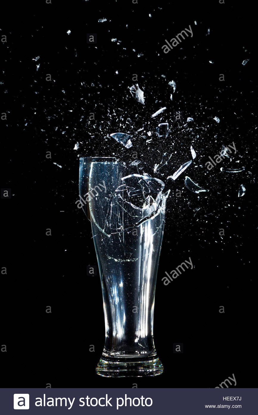 Exploding Glass Cup Shattering Over Black Background Stock Photo