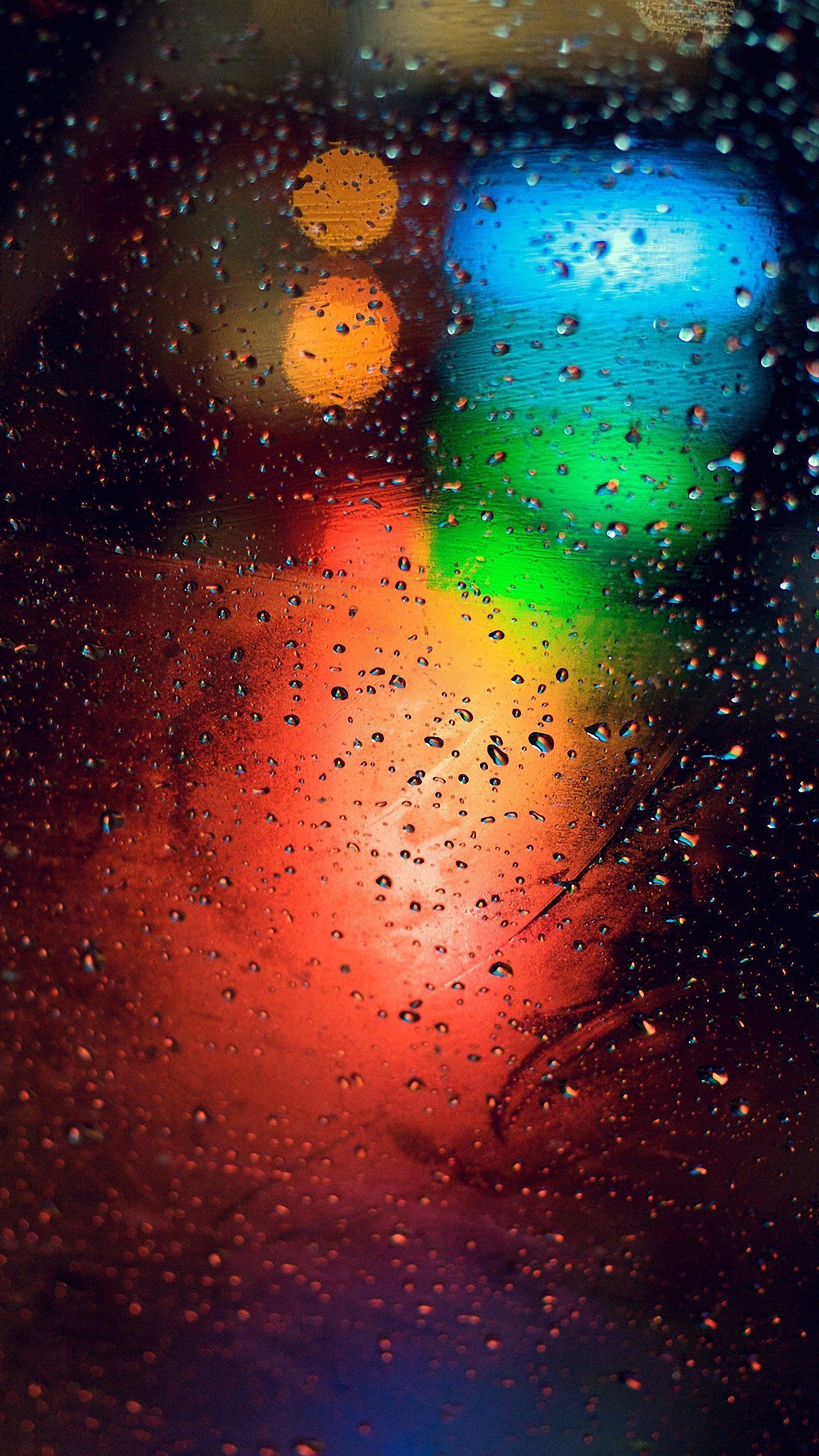 Abstract image of colorful lights blurred through a rain-covered window, perfect for a phone wallpaper
