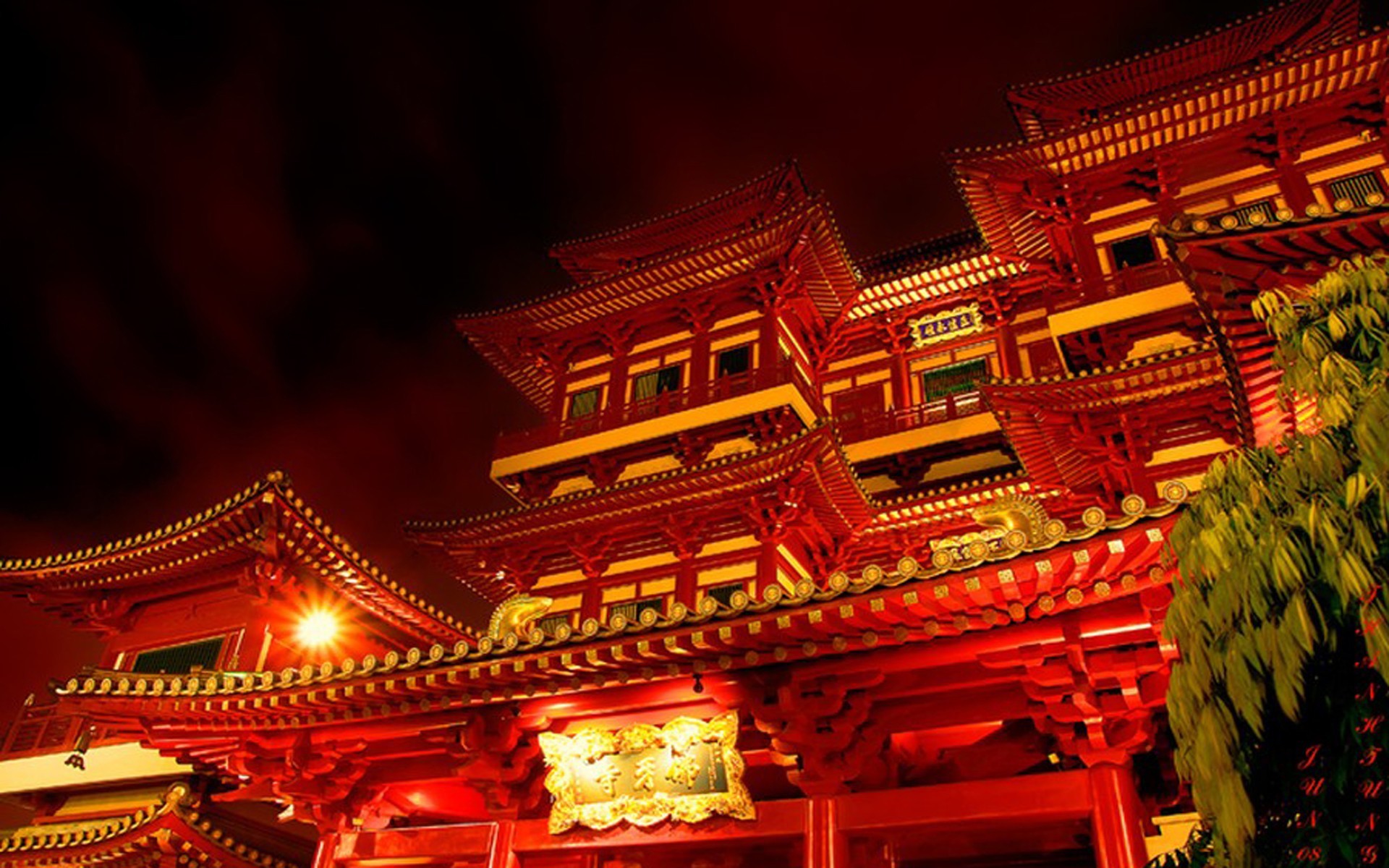 A vibrant, illuminated red and gold Chinese temple at night, showcasing intricate traditional architecture