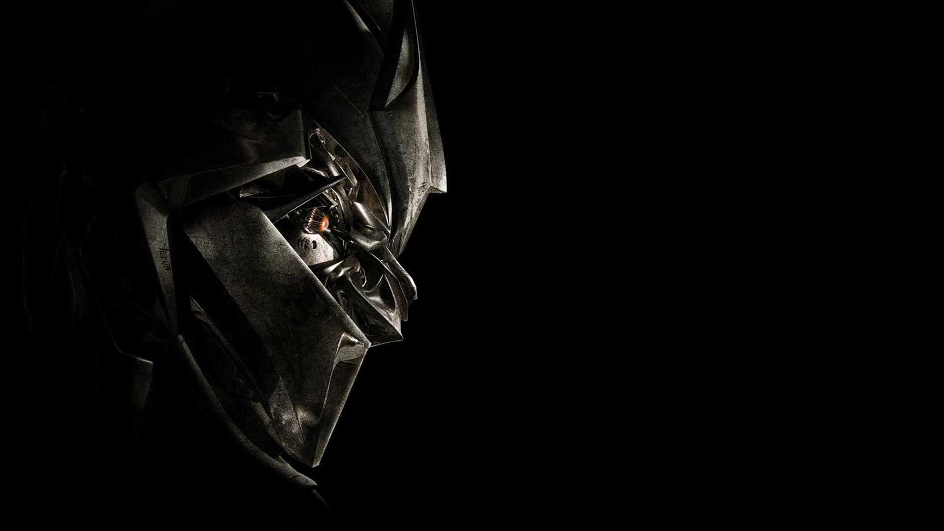 Dark, shadowy close-up of a metallic, robotic face, possibly a Transformer, against a completely black background