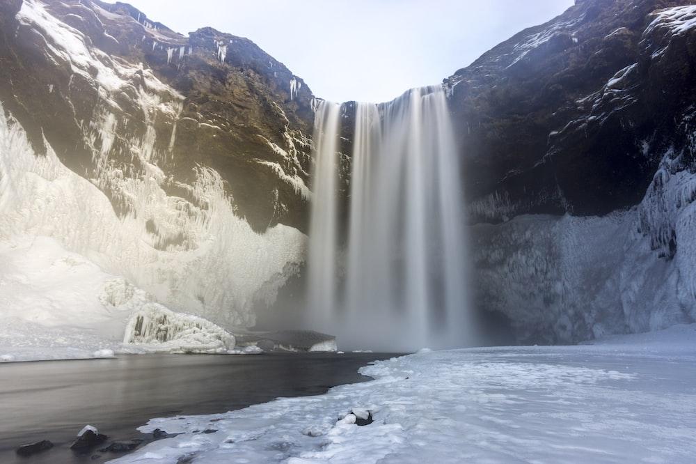 Waterfalls On Snow Covered Ground During Daytime Photo