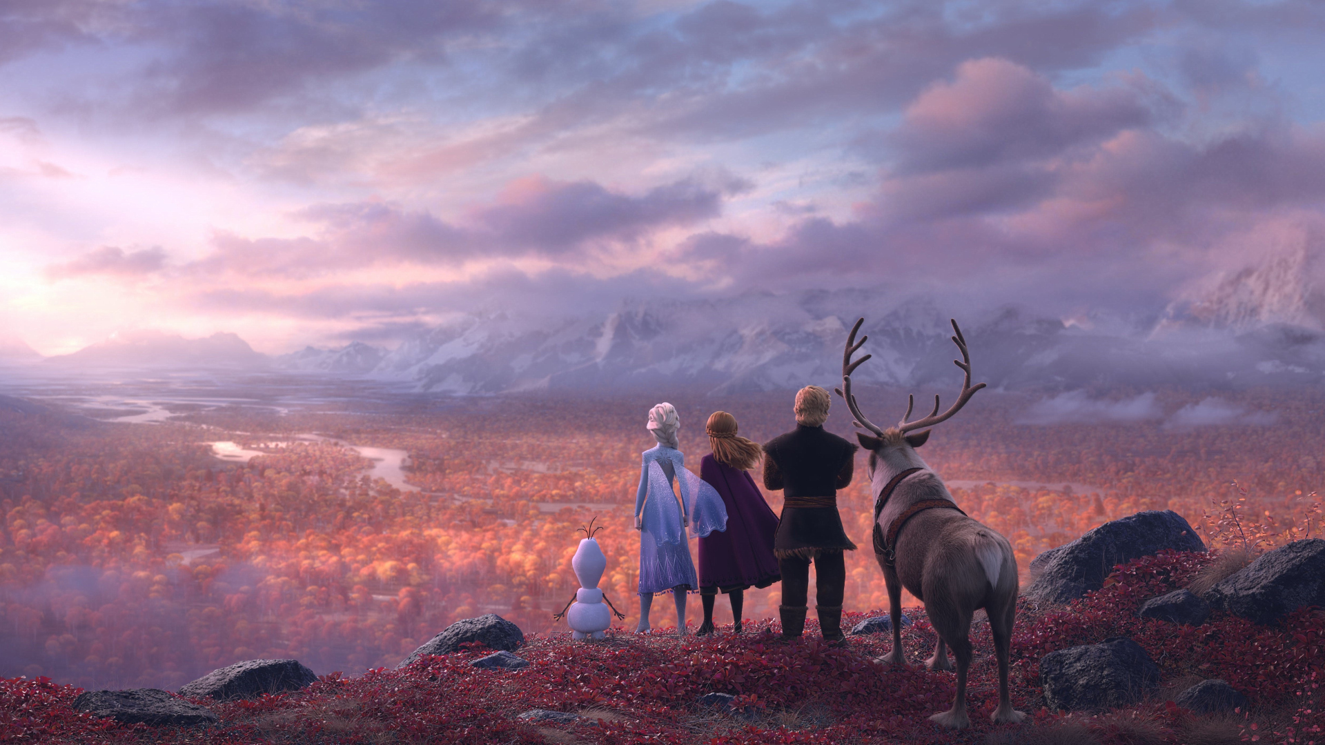 Elsa, Anna, Kristoff, Sven, and Olaf stand on a hilltop, gazing at the autumnal landscape below in a promotional image for Frozen 2
