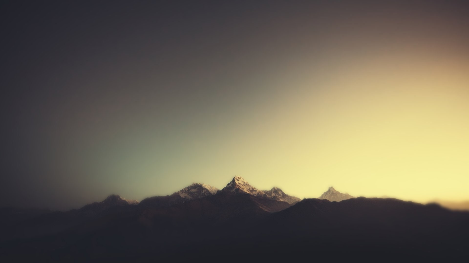 Minimalist mountain landscape at sunset with a soft, hazy glow