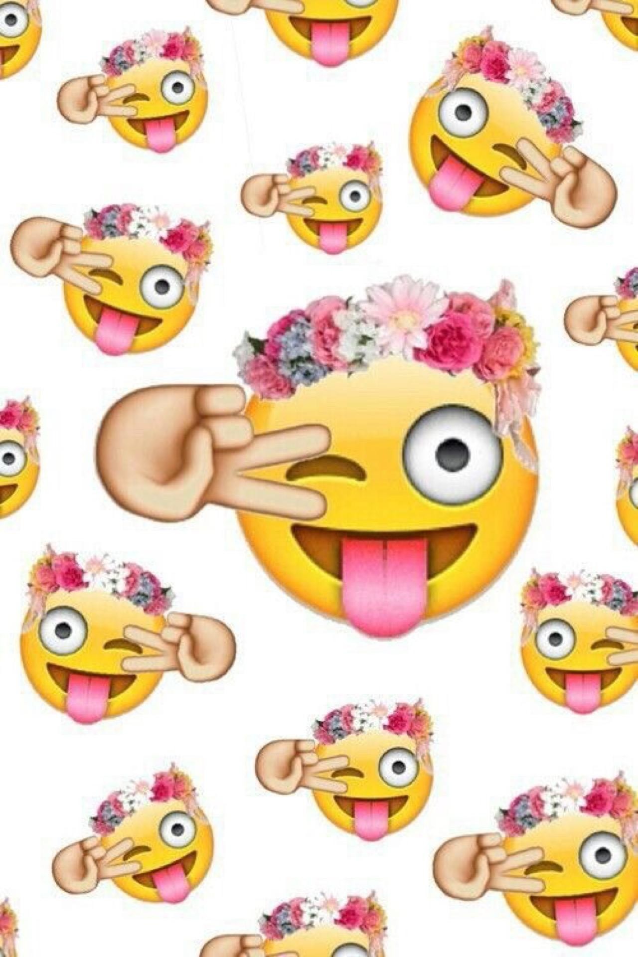 A fun and colorful wallpaper featuring a pattern of winking emoji faces with their tongues out, each wearing a floral crown and making a peace sign