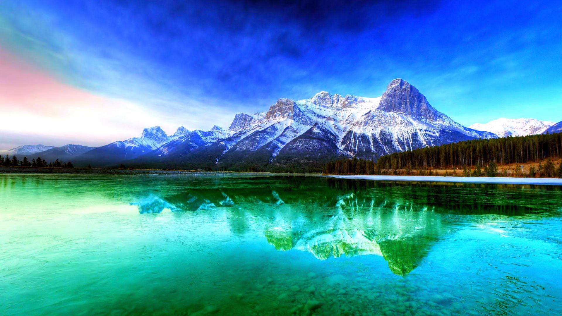 Stunning scenic wallpaper of snow-capped mountains reflected in a vibrant turquoise lake