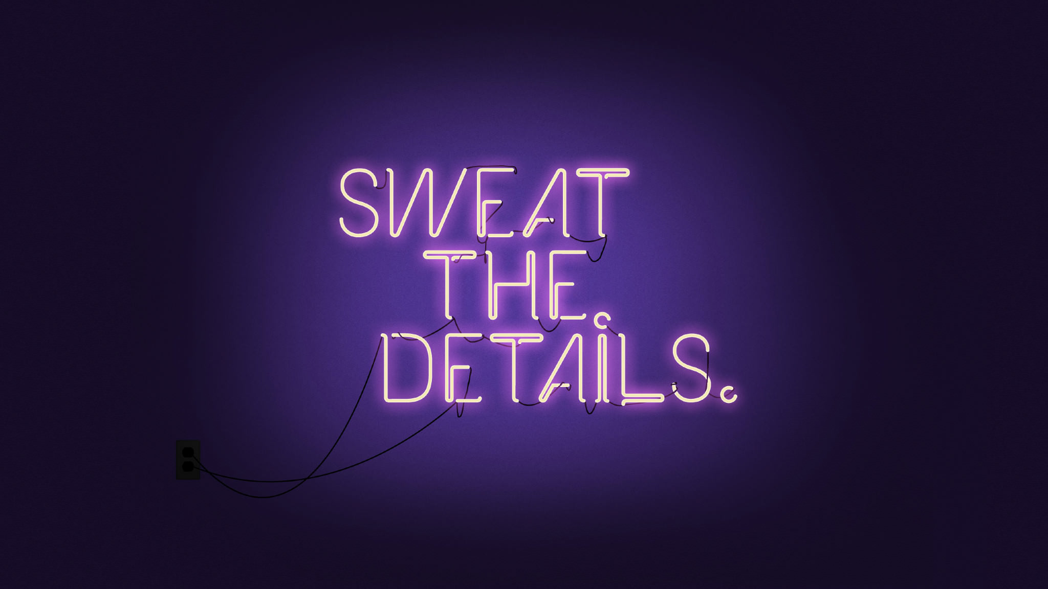 Neon sign with the motivational quote 'Sweat the Details' on a dark purple background