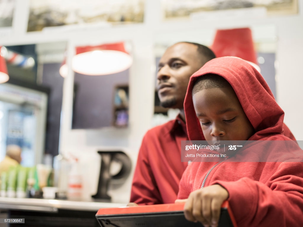 Black Father And Son Waiting In Retro Barbershop High Res Stock