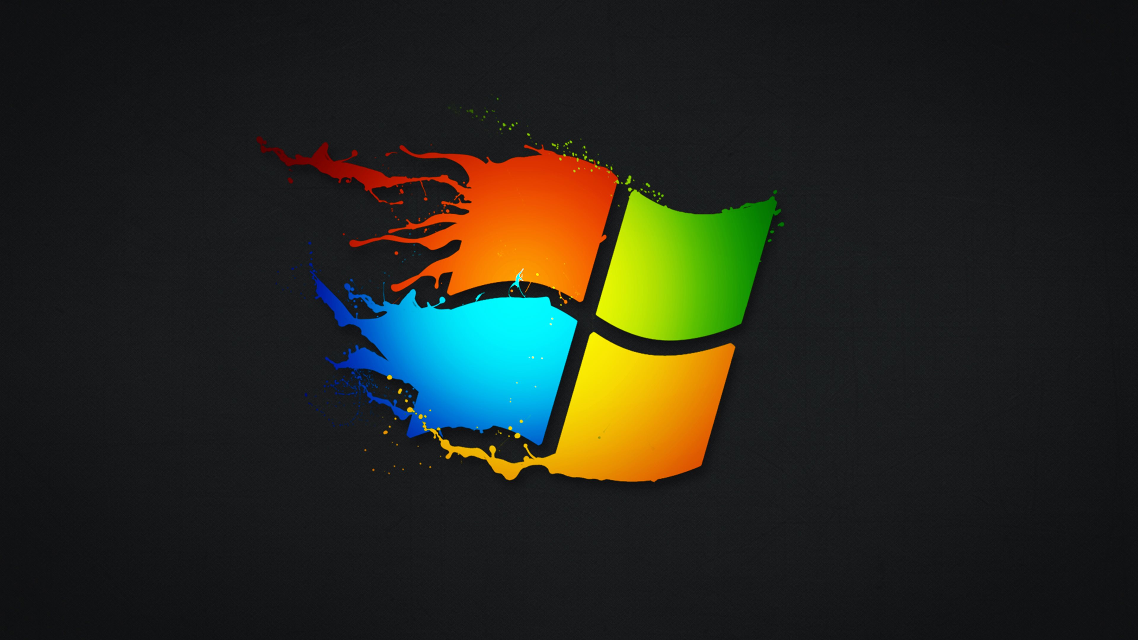 A vibrant, artistic splash of color forms the iconic Windows logo against a dark background, ideal for a modern and creative desktop