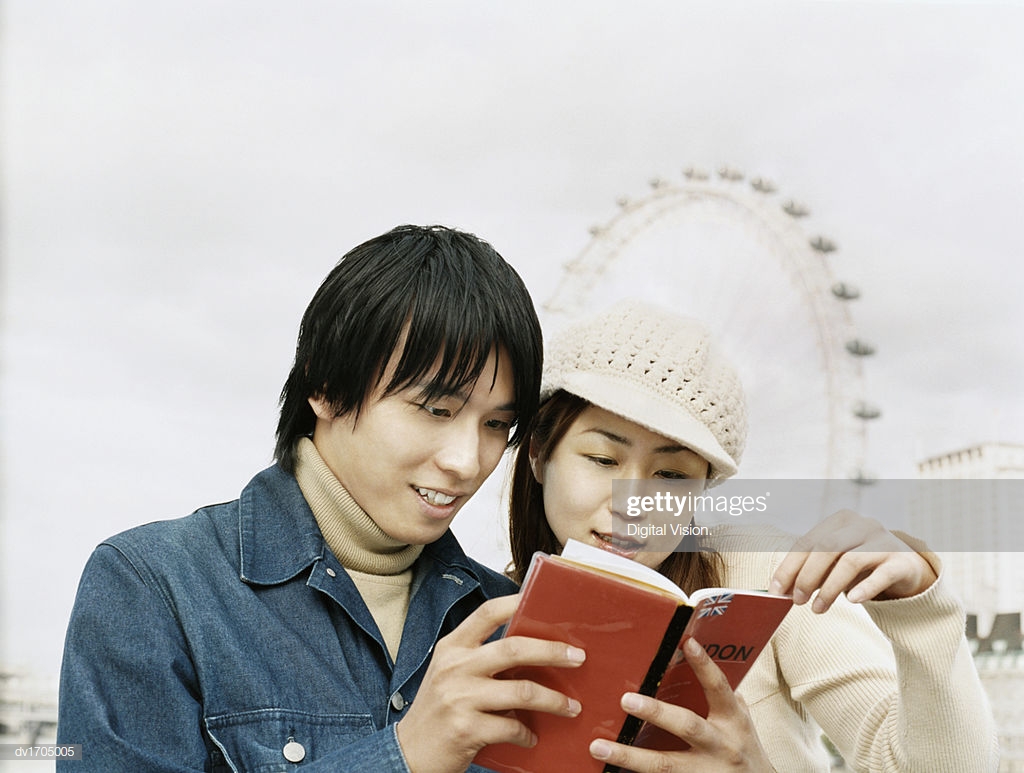 Young Couple Stand Side By Reading A Travel Guide Millenium