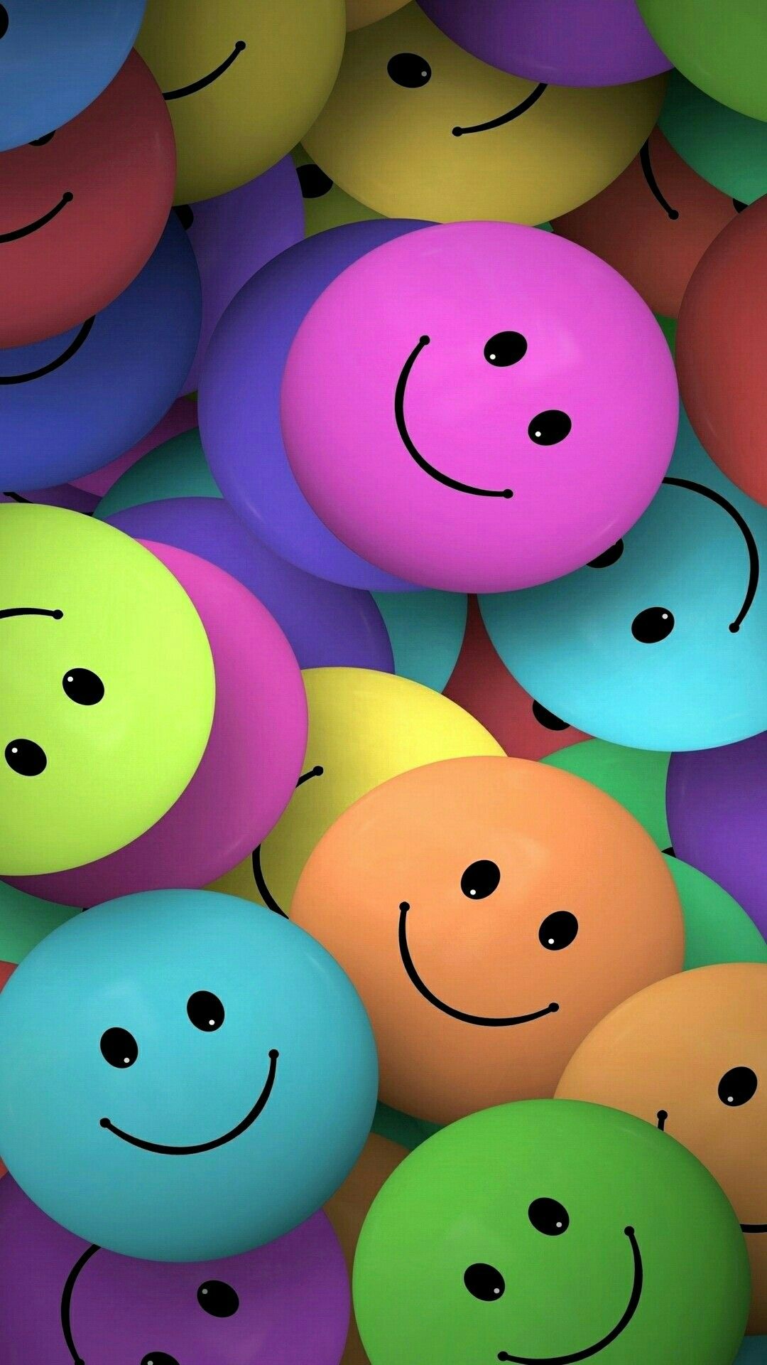 A cheerful cluster of colorful emoji faces, each with a simple smile and two black dot eyes, creating a vibrant and positive wallpaper