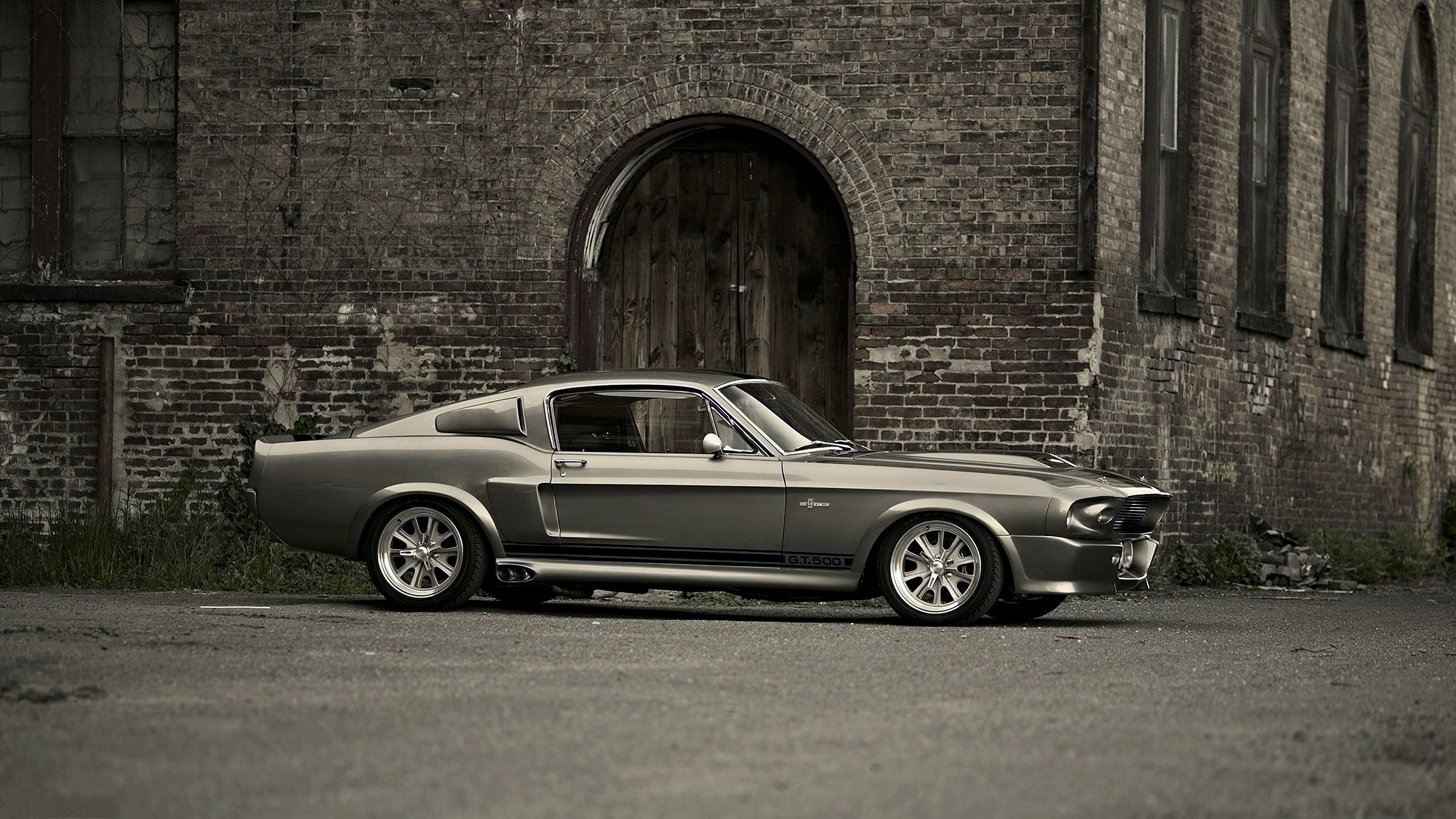 Classic Ford Mustang Shelby GT500 parked in front of an old brick building