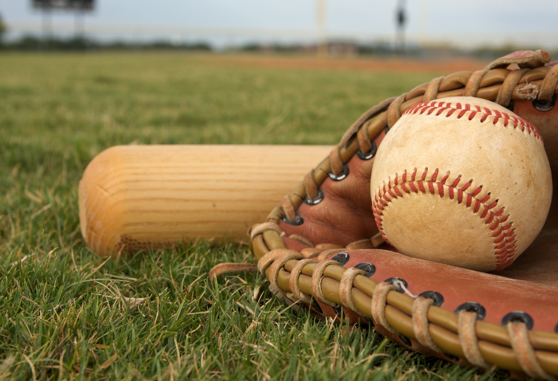 Baseball and glove on a grassy field, evoking the classic American pastime