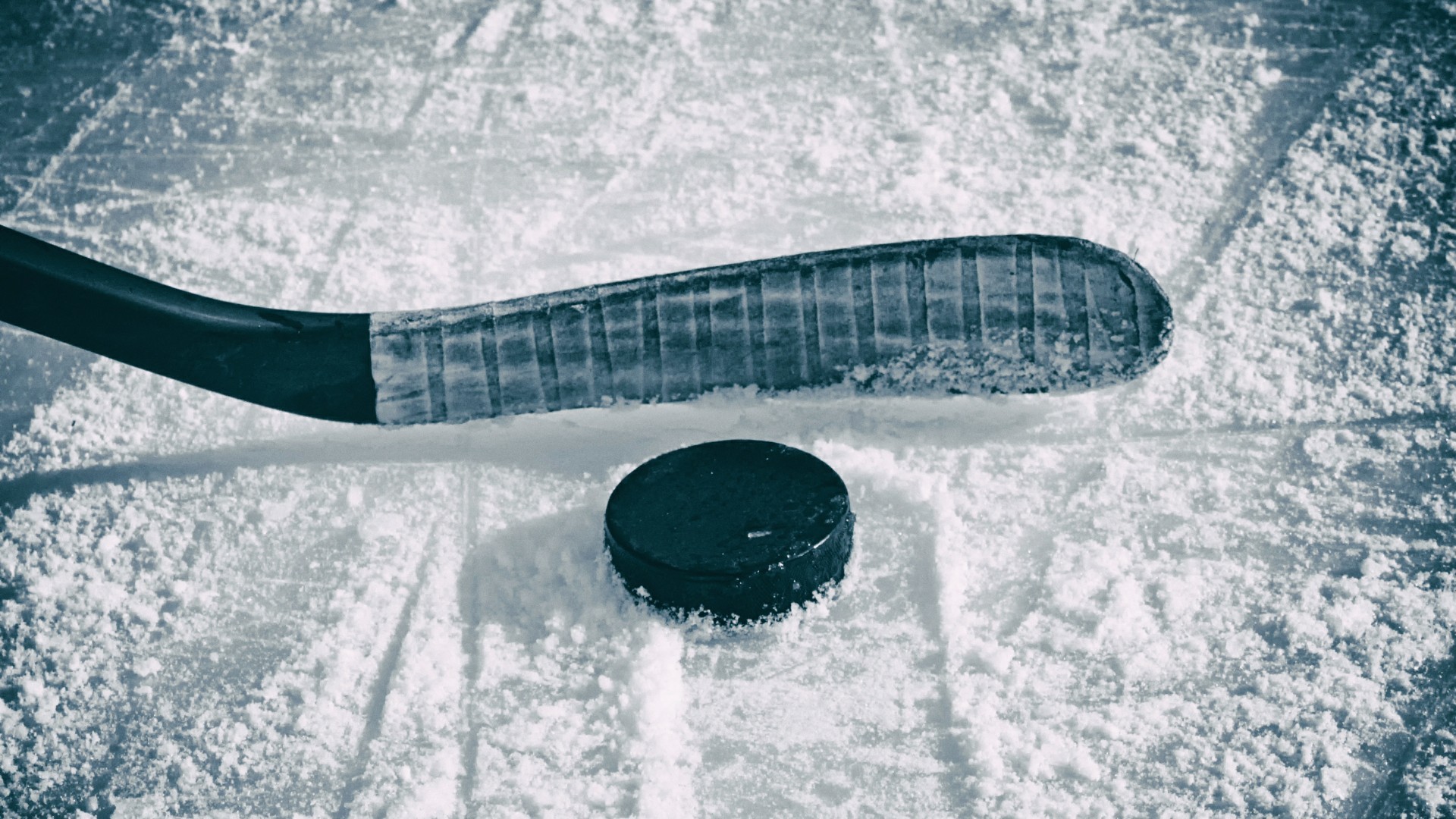 Close-up of hockey stick and puck on ice, perfect for hockey enthusiasts