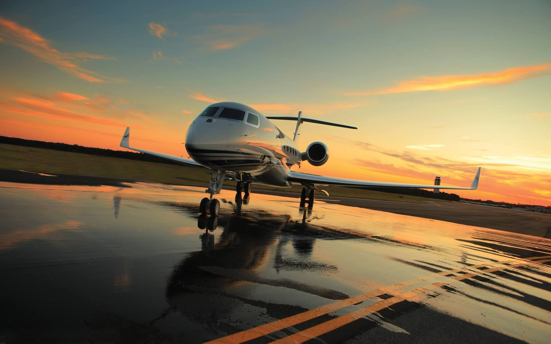 Private jet on a wet tarmac at sunset