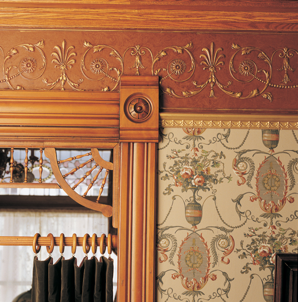 neoclassical frieze hung over cherry woodwork is made of embossed