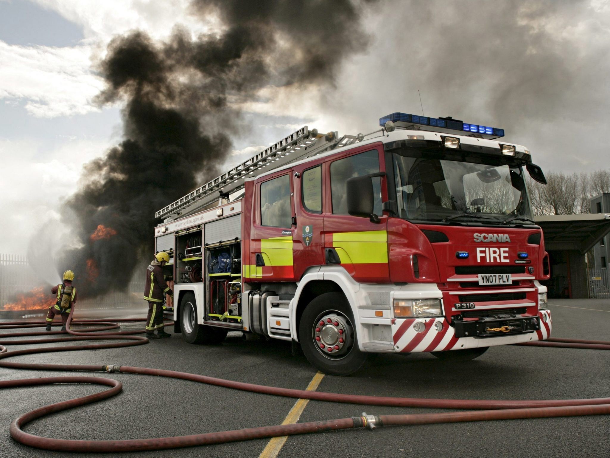 Firefighters battling a blaze with a Scania fire truck