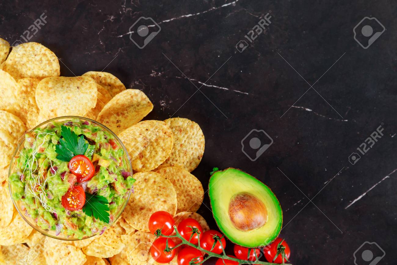 Guacamole Doritos With Nachos And Avocado On Stone Dark Background