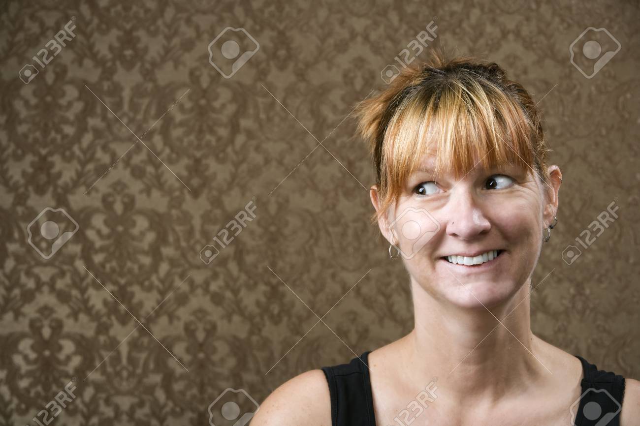 Pretty Woman Smiling In Front Of A Gold Flocked Wallpaper
