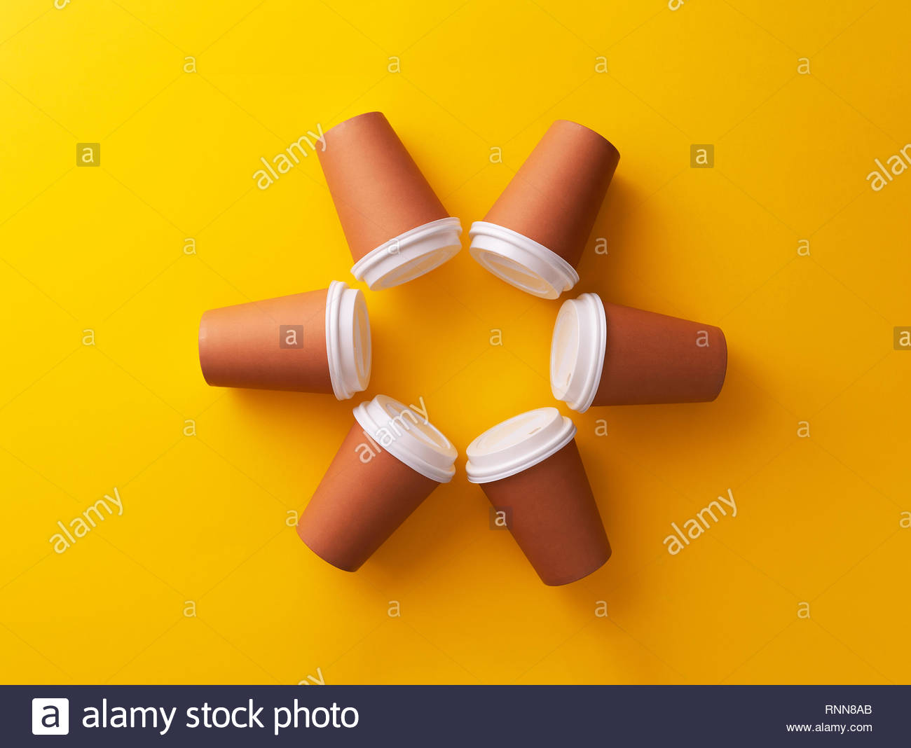 Multiple Disposable Coffee Cups Organized In A Circle Over Yellow