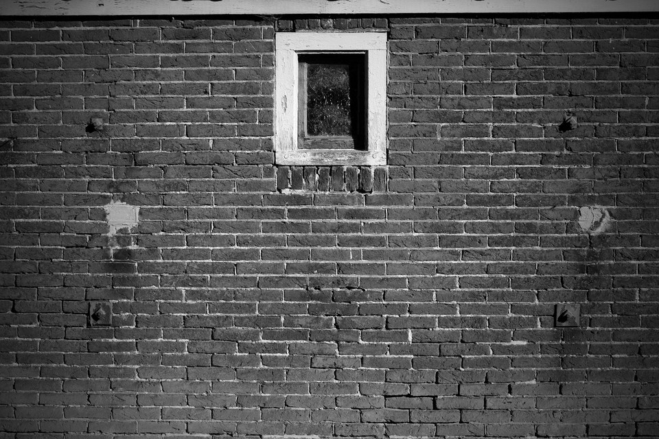 Old brick wall background with a windows in black and white by