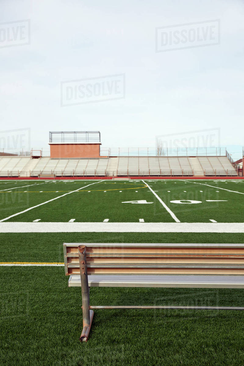 American Football Field With Bench In Foreground And Empty