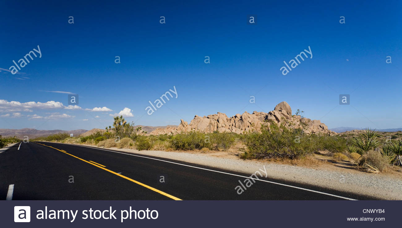 Country Road In Mojave Desert And Granite Rocks Background Usa