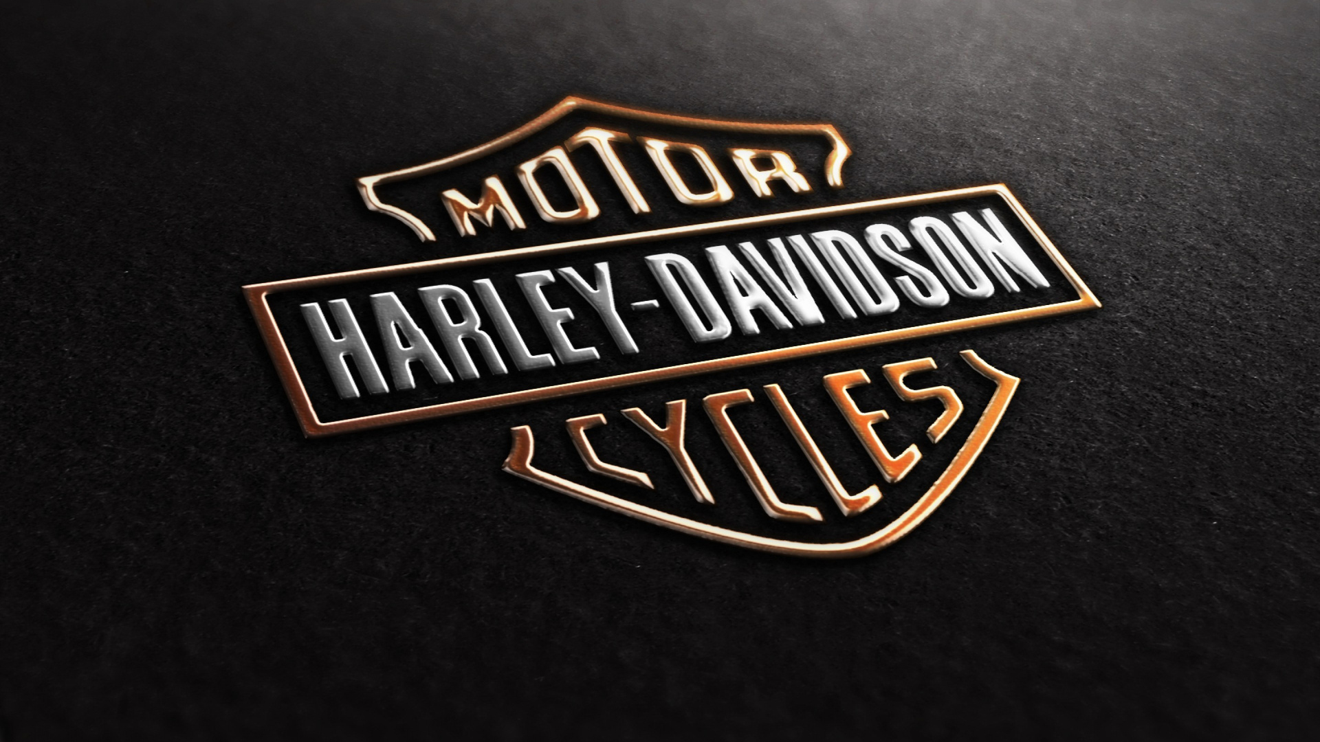 A close-up, embossed rendering of the iconic Harley-Davidson logo, gleaming against a textured black backdrop