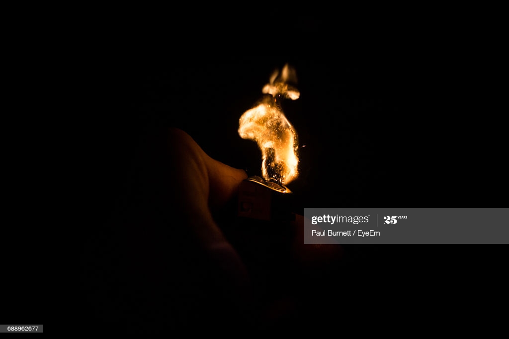 Illuminated Cigarette Lighter Against Black Background High Res