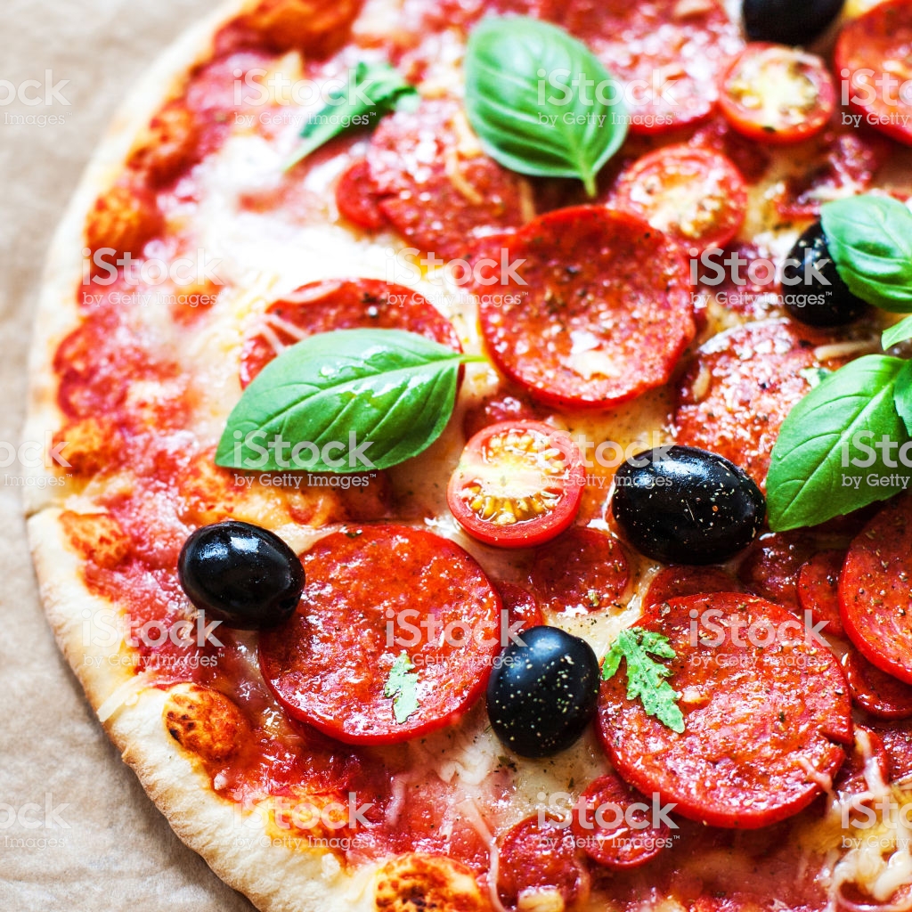 Pepperoni Pizza With Fresh Ingredients On Brown Baking Paper