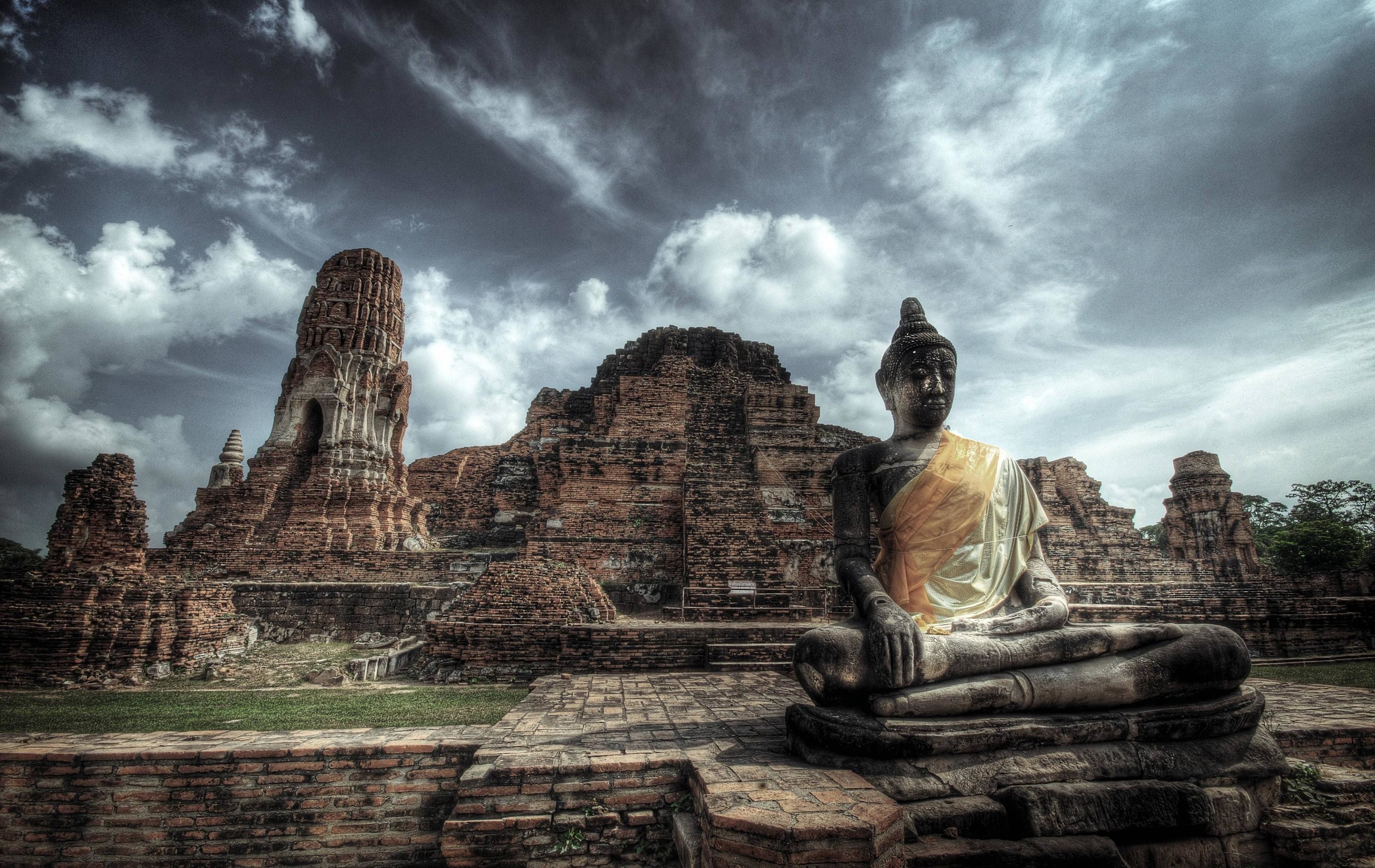 Serene Buddha statue amidst ancient temple ruins in Ayutthaya, Thailand