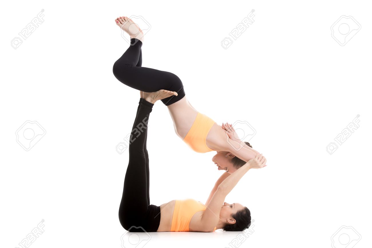 Two Sporty Girls On White Background Doing Acroyoga Yoga With