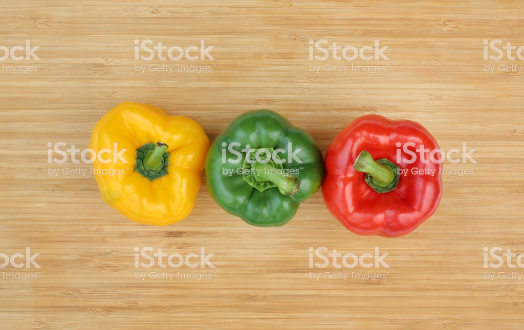 Green Red And Yellow Bell Pepper On Wood Background Stock Photo