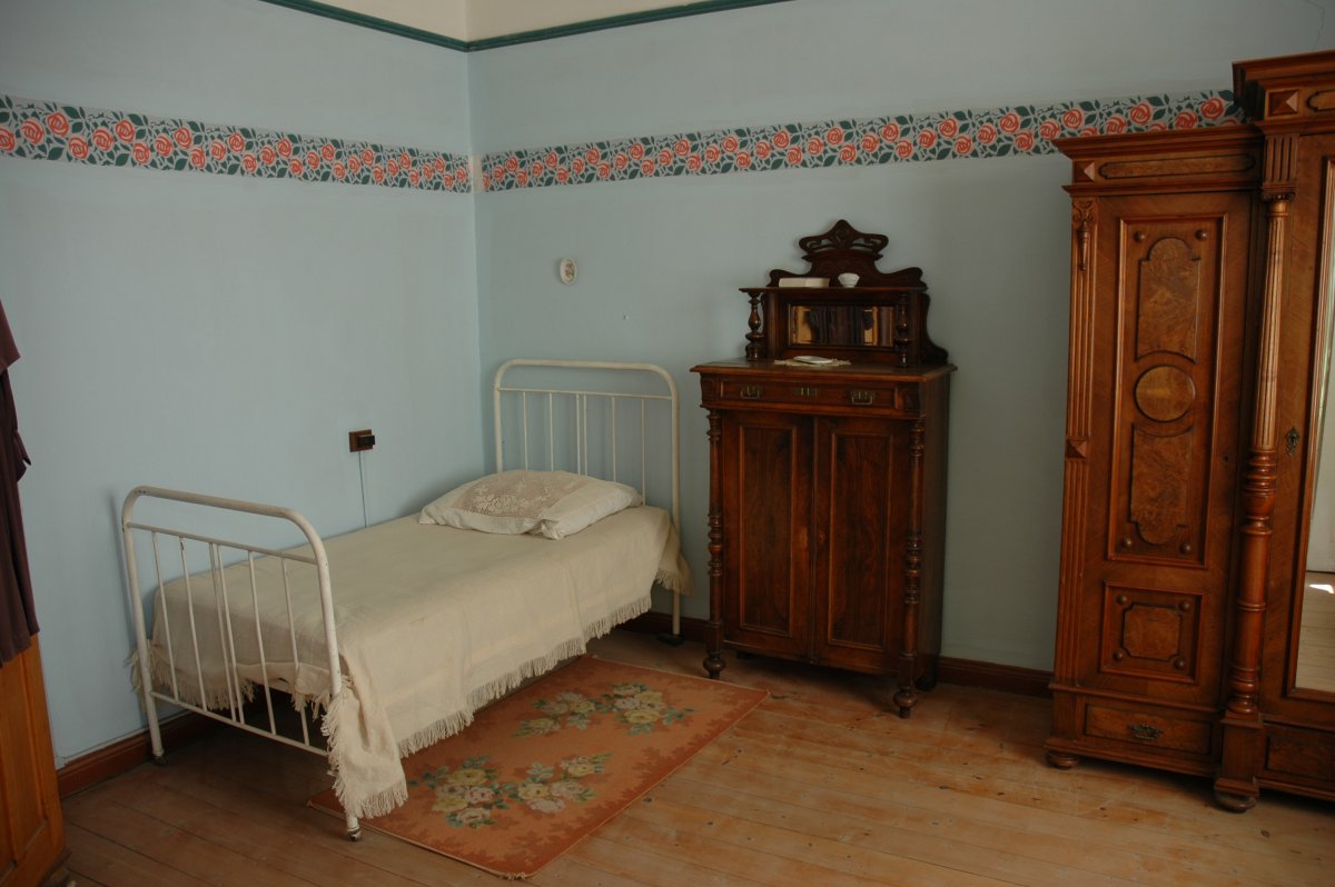 Even A Turn Of The Century Bed Armoire And Rug Remain In This Room