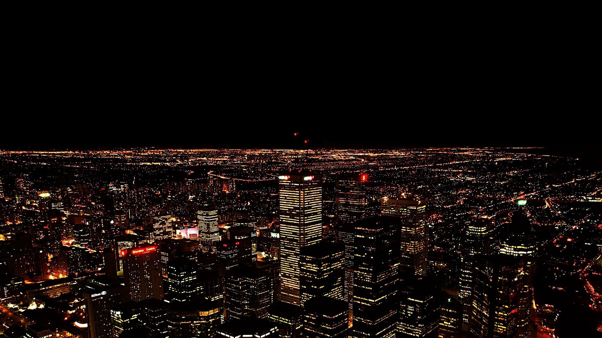 An Aerial Of The City Lights At Night From High Up In Skyscrapers Wallpaper