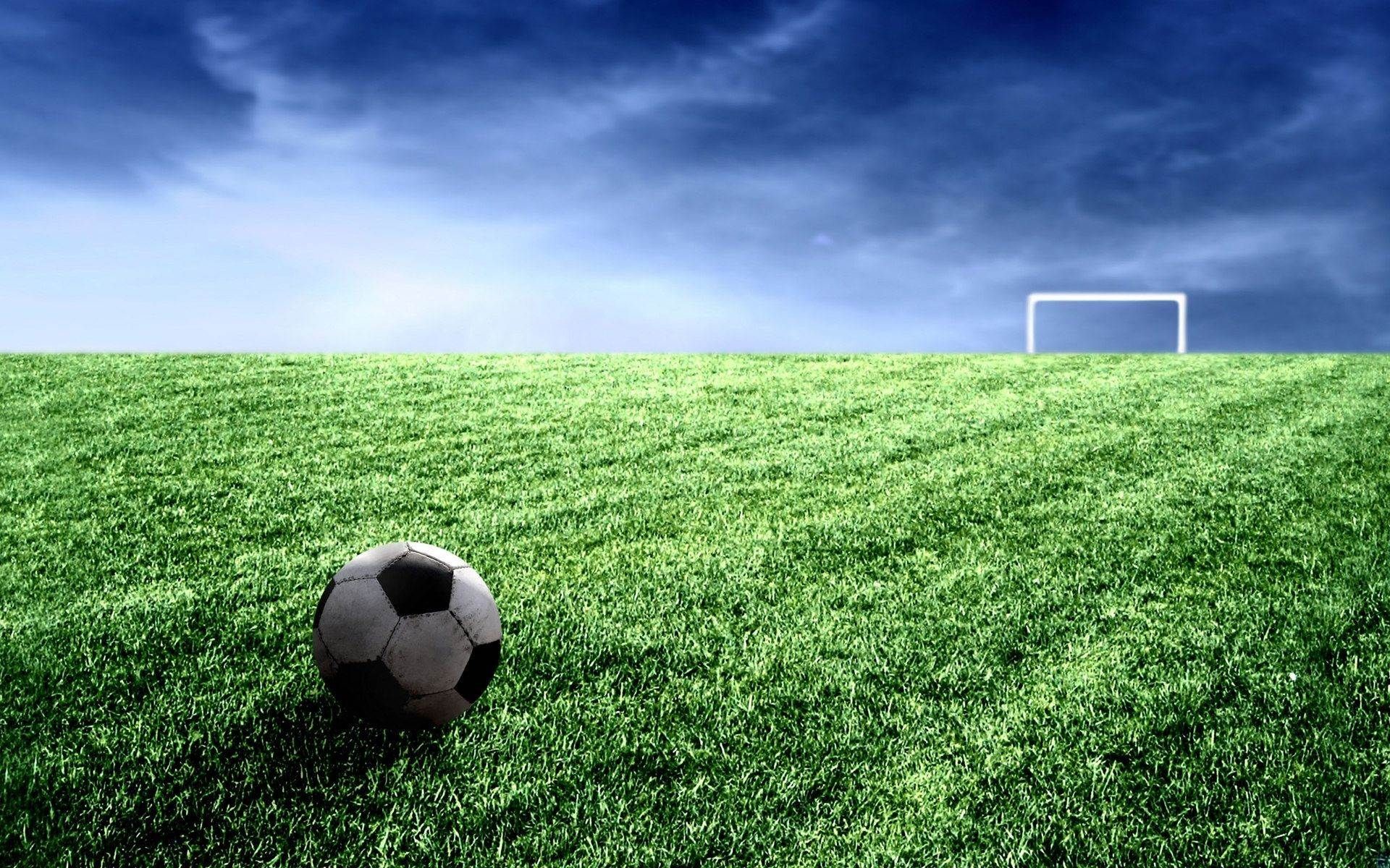 A classic black and white soccer ball sits on a vibrant green field, with a goalpost in the distance under a dramatic sky. Perfect for Nike football enthusiasts